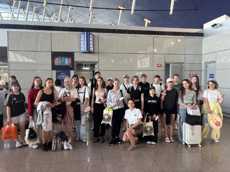 Группа учеников с чемоданами в холле перед отъездом домой